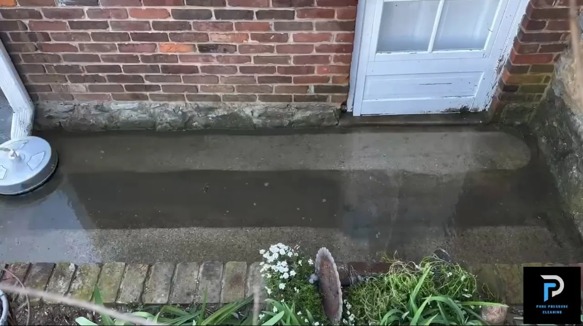 Rinsing a concrete strip against the house